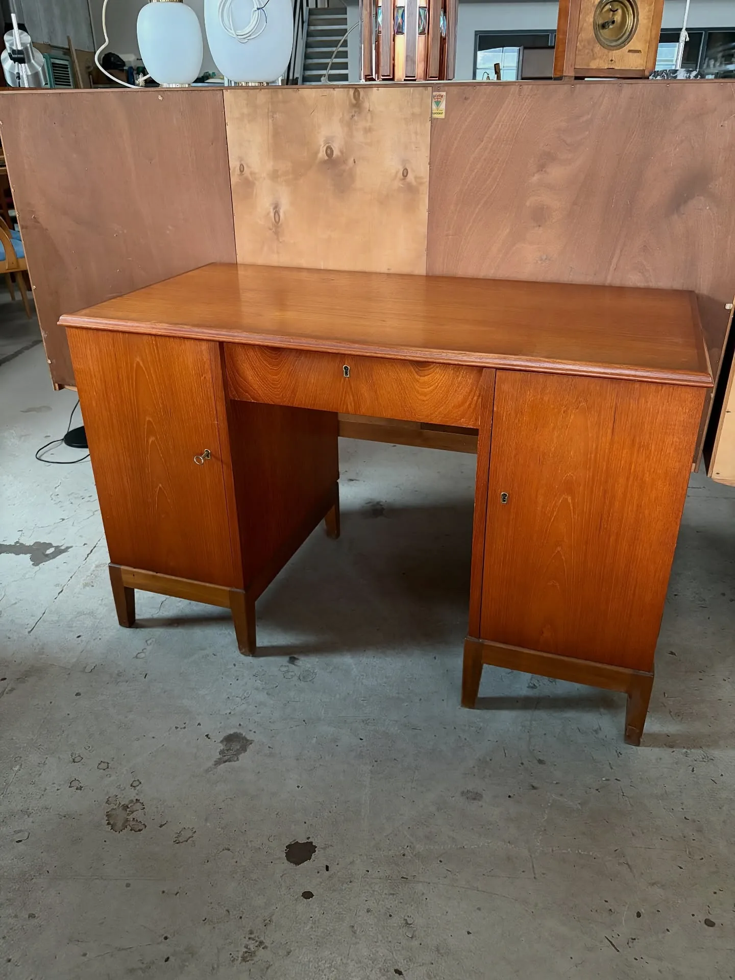 Teak skrivebord 

Dansk 50’erne.
Skuffe samt 2 skabe med hylder og skuffer.

L 120 B 60 H…