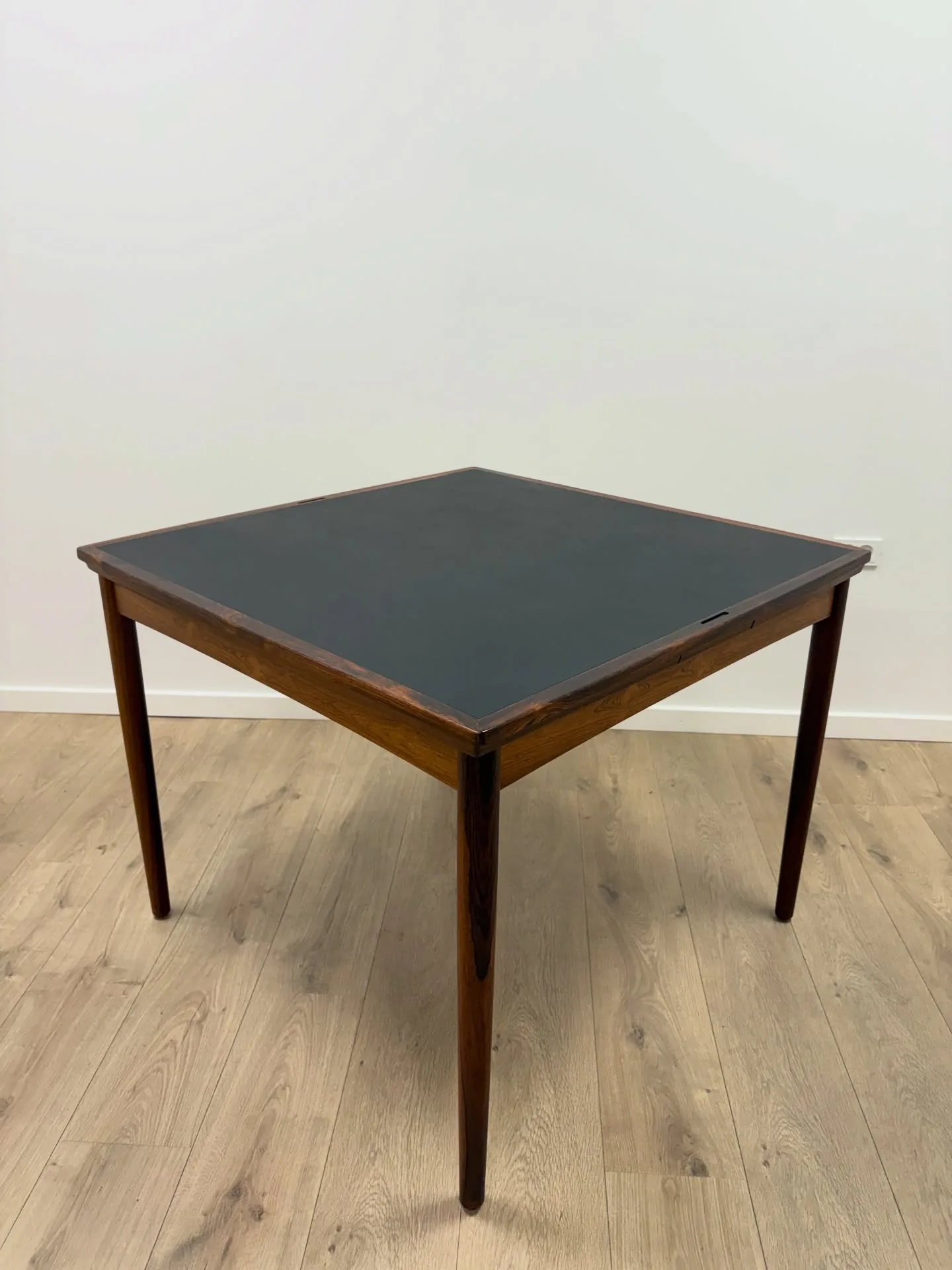 Hundevad 

Kvadratisk spillebord 
i palisander, vendbar plade med sort vinyl, udtræk, run…