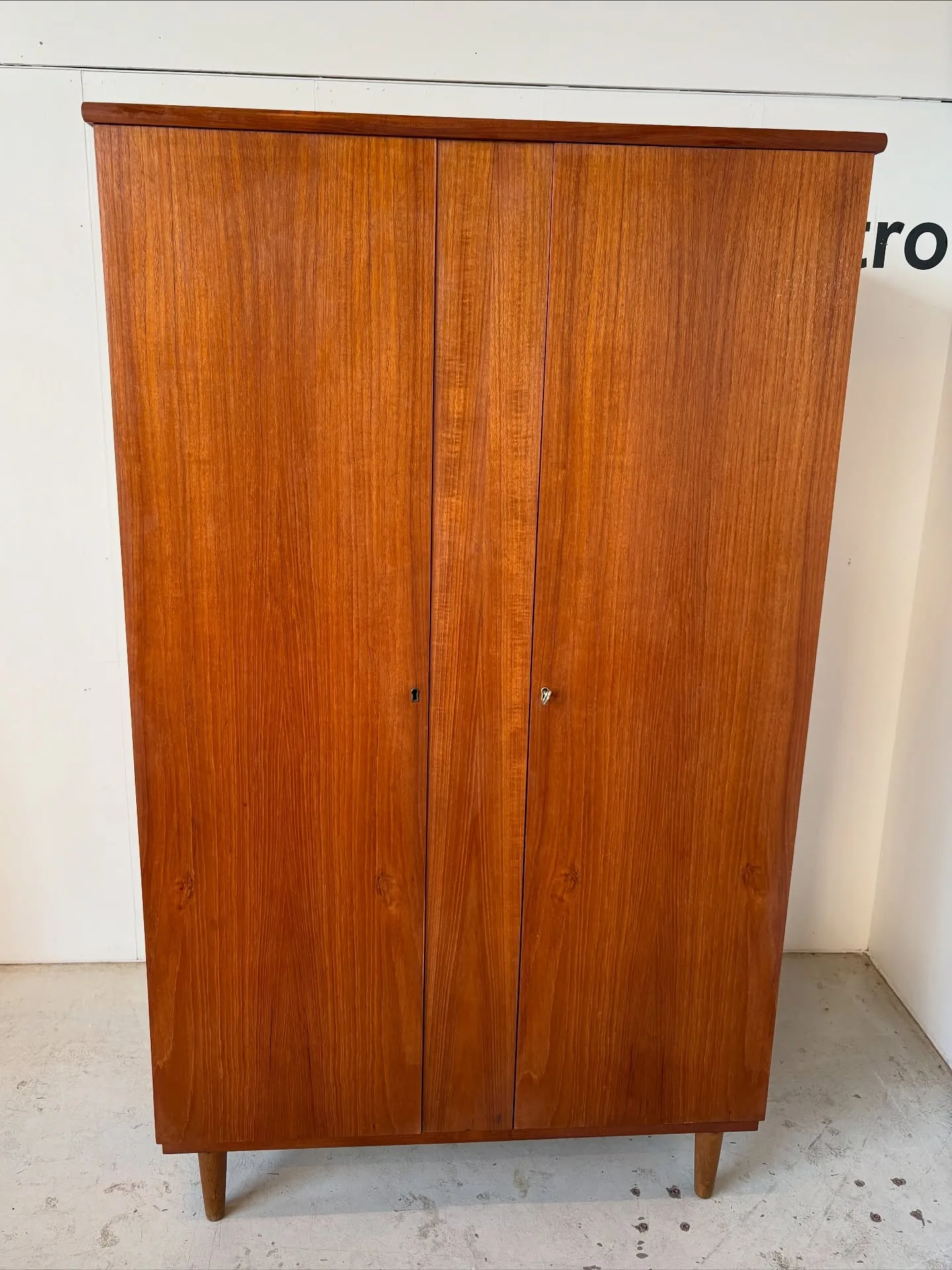 Teak klædeskab 

2 låger med bøjlestang og hylder bag. Monteret på ben i eg.
Dansk 60’ern…